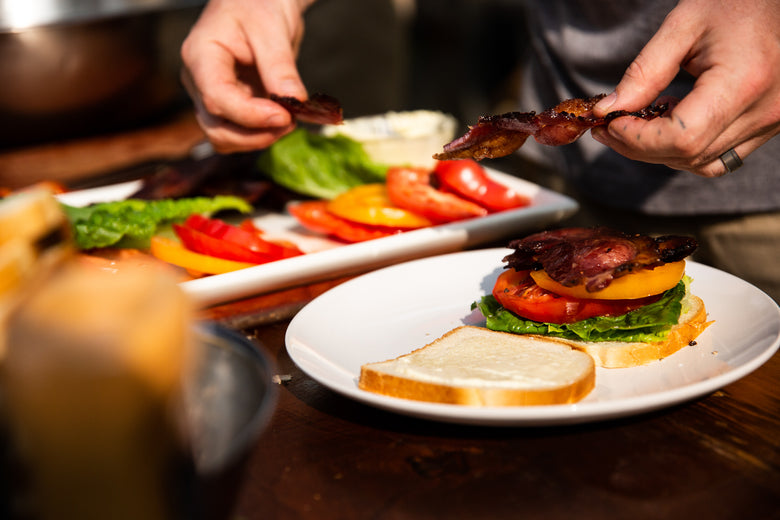 Bacon being used to make a BLT sandwich