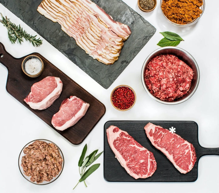 Assorted Porter Road meats including steaks, bacon, pork chops, and sausage